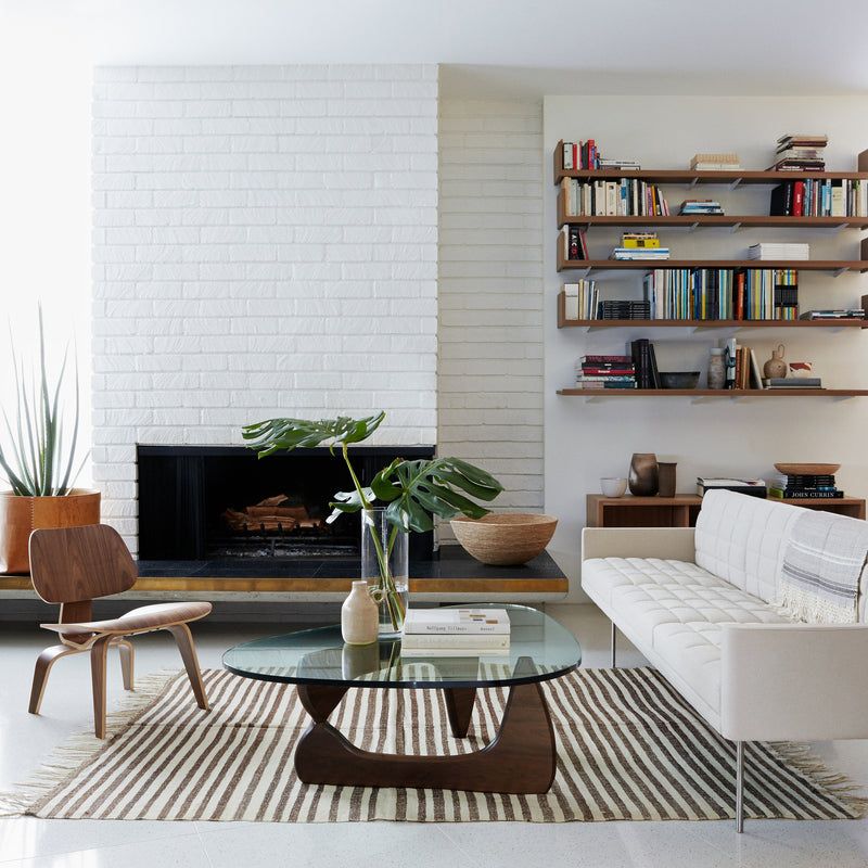 Innist sculptural coffee table in walnut, lifestyle living room setting with biomorphic wooden base and tempered glass top
