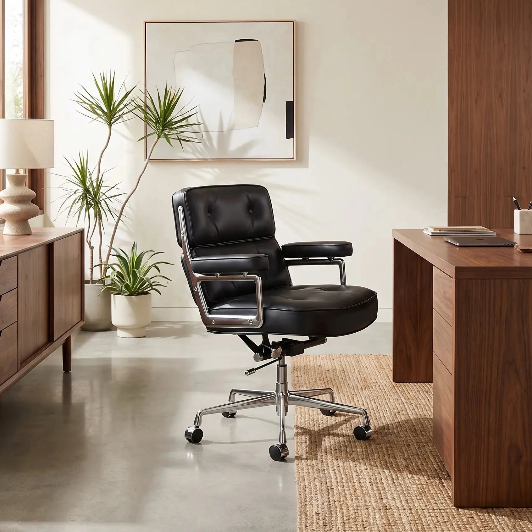 Mid-century executive office chair in black full-grain leather beside a walnut desk in a bright home office